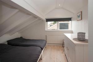 Habitación pequeña con cama y lavamanos en Buitenhuis Egmond en Egmond aan den Hoef