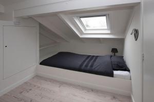 a bed in a room with a window at Buitenhuis Egmond in Egmond aan den Hoef