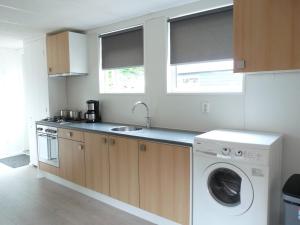 a kitchen with a washing machine and a washer at Zomerhuis Duinzicht in Egmond aan den Hoef
