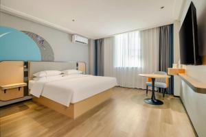 a bedroom with a bed and a table and a desk at City Comfort Inn Wuzhou Wangcheng Square in Wuzhou +234 photos