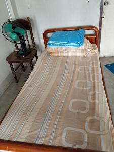 a large bed in a room with a chair at Moonshadow in Sungai Kolok