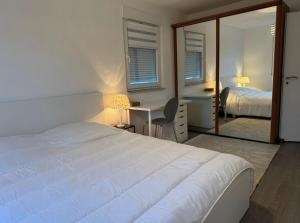 a bedroom with a bed and a desk and a mirror at Logement Moderne in Mundolsheim