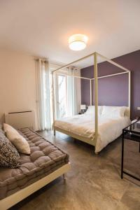 sypialnia z łóżkiem z baldachimem i dużym oknem w obiekcie Cascina Belmonte w mieście Fossano