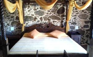 a bedroom with a bed in a stone wall at Confortable Alojamiento con Piscina y Estilo in Villaverde +7 photos
