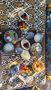 a table topped with bowls of fruit on a table at Samar Oasis in Bukhara