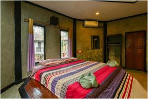 a bedroom with a large bed with towels on it at Tamsabai Resort in Ban Na Nian