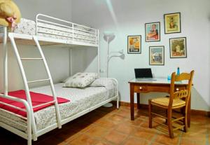 ein Schlafzimmer mit einem Etagenbett und einem Schreibtisch mit einem Laptop in der Unterkunft Vivienda Rural El Retiro in Villanueva del Rey + 24 Fotos