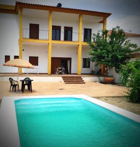 ein großes Schwimmbad vor einem Haus in der Unterkunft Vivienda Rural El Retiro in Villanueva del Rey