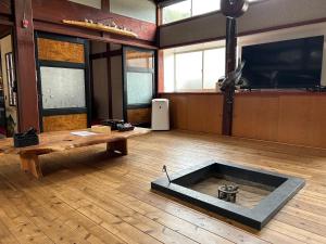 una stanza con pavimento in legno con un tavolo e un tavolo sidx sidx di 笑庵emian a Hakusan