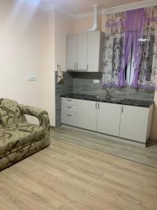 a kitchen with white cabinets and a couch in a room at Hamuni in Elar