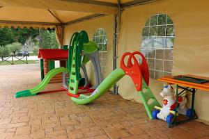 a play tent with a slide and a table at Agriturismo La Valle dei Fiori di Bellucci Rosanna in Torre deʼ Calzolari