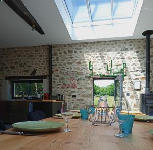a dining room with a table with glasses on it at Superbe grange rénovée in Saint-Sulpice-le-Guérétois