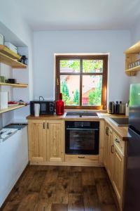 a kitchen with wooden cabinets and a window at Jókai Guesthouse in Tuşnad