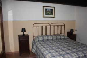 a bedroom with a bed with a plaid blanket and a nightstand at Azienda Agrituristica Le Puzelle in Santa Severina