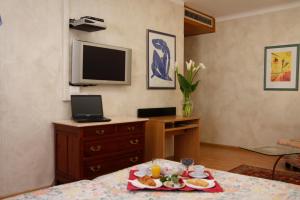 ein Wohnzimmer mit einem Tisch und einem Teller mit Lebensmitteln in der Unterkunft Hotel Centro in Torre Pellice