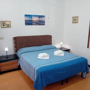 a bedroom with a blue bed with two towels on it at Casa Milanesi in Monterosso al Mare