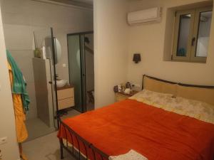 een slaapkamer met een oranje bed en een spiegel bij ALONI retreat in Proástion