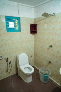 une salle de bain avec des toilettes blanches et une fenêtre dans l'établissement Temple tree garden beach, à Varkala