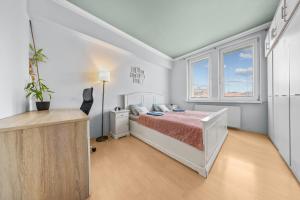 une chambre blanche avec un lit et une fenêtre dans l'établissement Big 4-room SPACIOUS apartment, à Bratislava