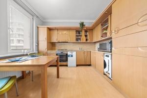 une cuisine avec des armoires en bois et une table en bois dans l'établissement Big 4-room SPACIOUS apartment, à Bratislava