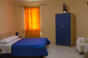 サンニコーラにあるB&B L'Angoloのベッドルーム1室(ベッド1台、青いキャビネット、窓付)