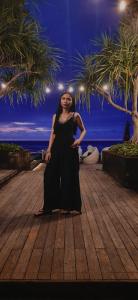 a woman in a black dress standing on a wooden floor at Cozy Villa Adrima, Bali, Canggu area in Mantaak