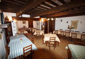 a restaurant with several tables and chairs and a room with tables and chairsktop at Agriturismo La Valle dei Fiori di Bellucci Rosanna in Torre deʼ Calzolari