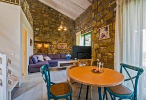 a living room with a table and chairs and a couch at Mediterraneo Luxury Suites Halkidiki in Vourvourou