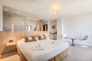 a bedroom with a large white bed with mirrors at Grand Hotel Du Golfe - Spa & Restaurant in Collioure