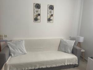 salon z kanapą i 2 zdjęciami na ścianie w obiekcie Heaven Studios & Apartments w mieście Stalida