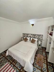 a bedroom with a large white bed in a room at Maison Berj in Oualidia