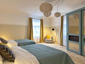 Un dormitorio con dos camas y una ventana. en Henrietes Apartamenti, en Kuldīga