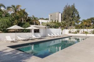 a swimming pool with chairs and umbrellas next to a building at Grand Hotel Du Golfe - Spa & Restaurant in Collioure