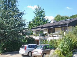 dos autos estacionados frente a una casa en B&B Hersberg, en Hersberg