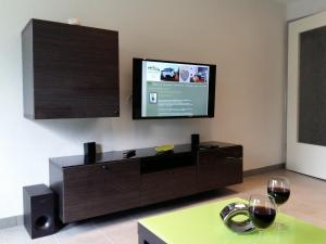 a living room with a tv and two glasses of wine at Ferien in Goslar, Freiers Ferienwohnungen in Goslar