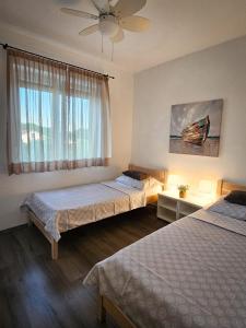 a bedroom with two beds and a window at Apartman TIA in Vir