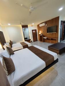 a hotel room with two beds and a television at Hotel Shivtara in Nānded