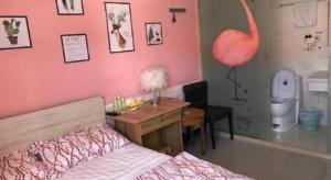 a bedroom with a pink wall with a desk and a bed at Lianyungang Jianyuan Hotel in Nancheng +236 photos