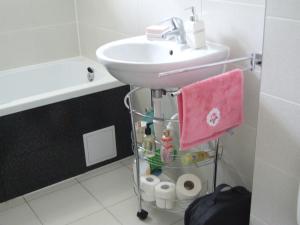een badkamer met een wastafel en een roze handdoek bij Anca Apartment in Braşov +62 foto's