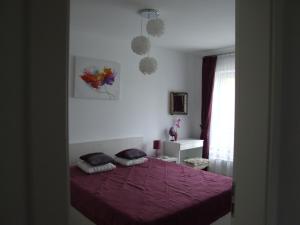 een slaapkamer met een paars bed met 2 kussens bij Anca Apartment in Braşov
