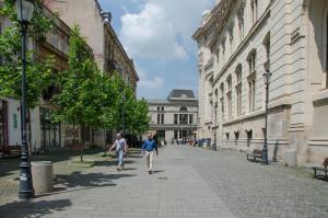 2 personnes marchant dans une rue d'une ville dans l'établissement Old City by CityLife Suites, à Bucarest