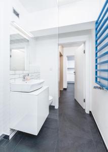 a white bathroom with a sink and a toilet at Apartment Zegadłowicza in Kraków +11 photos