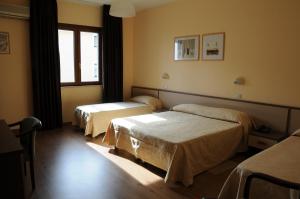 una camera d'albergo con due letti e una finestra di Hotel Barbieri ad Altomonte