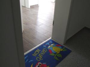 a door mat with a cartoon on it on the floor at Anca Apartment in Braşov