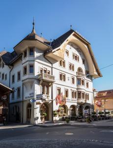 un grande edificio bianco sul lato di una strada di Hotel Landhaus a Gstaad