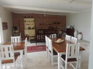 a dining room with a table and white chairs at Good Hope Farm in Sunland