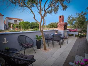a patio with chairs and a table and a tree at Apartman TIA in Vir