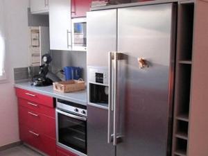 a stainless steel refrigerator in a kitchen with red cabinets at Mas de Perimont 28 in Fleury +8 photos