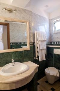 a bathroom with a toilet, sink and tub at Splendid Hotel Taormina in Taormina