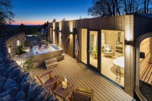 a house with a hot tub on a deck at Gilpin Hotel & Lake House in Bowness-on-Windermere